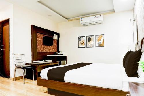 a bedroom with a bed and a desk with a desk at Super Collection O Kampoo Tiraha Road formerly Siddhi Vinayak in Lashkar