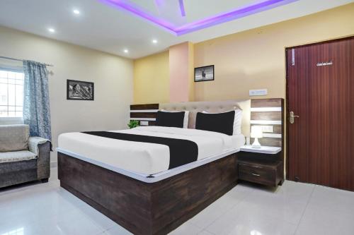 a bedroom with a large bed and a chair at Super Collection O Danapur Near Railway Station in Patna