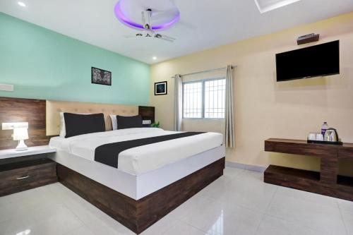 a bedroom with a large bed and a flat screen tv at Super Collection O Danapur Near Railway Station in Patna