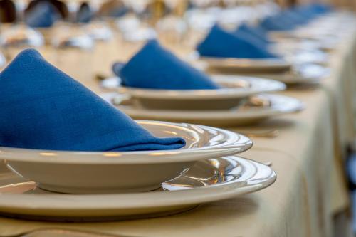 a row of plates with blue napkins on them at Hotel Moya in Honrubia