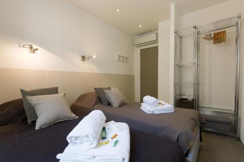 カンヌにあるAppartement design proche Croisette, classé 4 étoilesのベッド2台(タオル付)が備わる客室です。