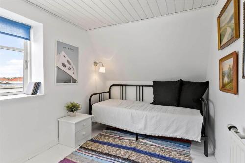 a white bedroom with a bed and a rug at BL1698-Blokhus-Sonder-i-by-21 in Blokhus