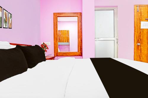 a bedroom with a white bed and a mirror at Super Hotel O Dighori Nagpur in Sakardarā