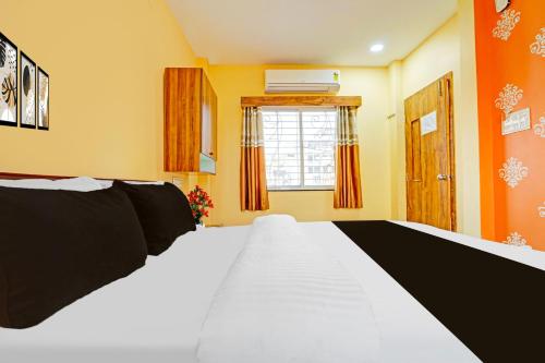 a bedroom with a large white bed and a window at Super Hotel O Dighori Nagpur in Sakardarā