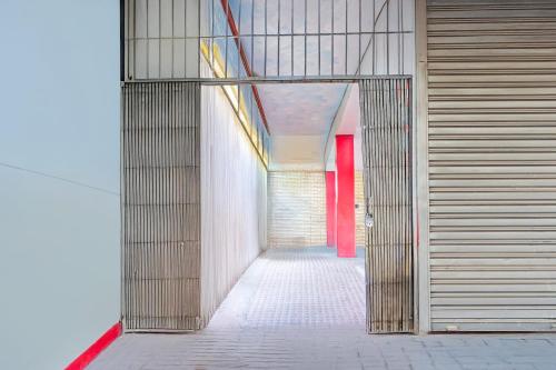 an empty hallway with red doors in a building at Super Hotel O Dighori Nagpur in Sakardarā