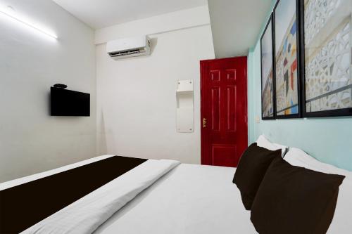 a bedroom with a bed and a red door at Super Hotel O Palarivattom Metro Station Formerly South Gate in Edappally