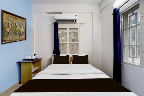 a bedroom with a bed and a window at Super Hotel O Palarivattom Metro Station Formerly South Gate in Edappally