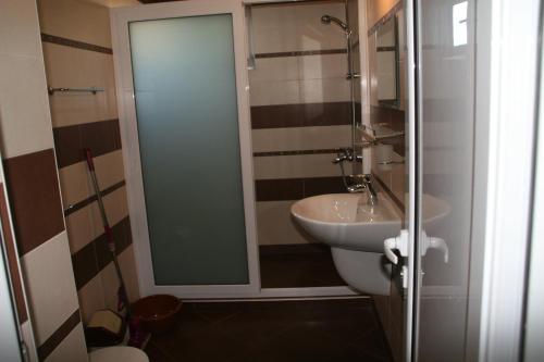 a bathroom with a sink and a glass shower at Ivatea Family Hotel in Ravda