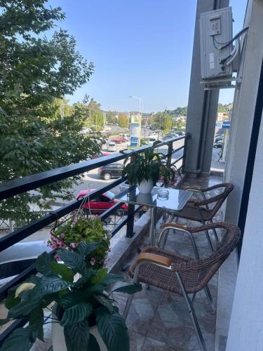 a balcony with a table and chairs and plants at Brean apartment in Vlorë