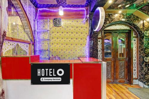 a hotel room with a sign on a counter and a door at Hotel O Residency Road Srinagar in Srinagar