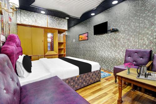 a bedroom with a bed and two purple chairs at Hotel O Residency Road Srinagar in Srinagar