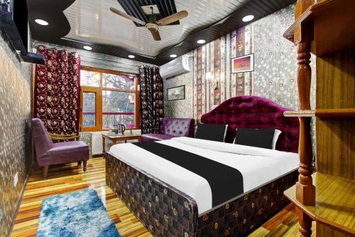 a bedroom with a large bed and purple chairs at Hotel O Residency Road Srinagar in Srinagar