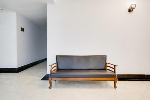a leather chair in a room with a white wall at Super Townhouse Margao Near Railway Station Formerly Hotel Tanish in Goa
