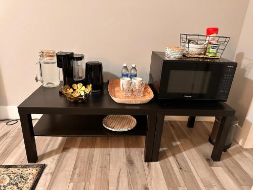 a black table with a microwave and a coffee maker at East Coast Cozy by Wastis-Easy Hwy, City & Airport Access plus Free Parking in Lower Sackville