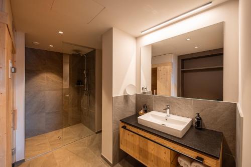 a bathroom with a sink and a shower at ADEA Lifestyle Suites Fieberbrunn in Fieberbrunn