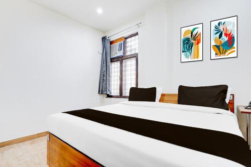 una camera da letto con un grande letto bianco e una finestra di Collection O Sector 62 Faridabad a Ballabgarh