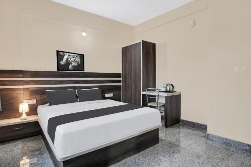 a bedroom with a large bed and a table at Super Collection O Peenya 2nd stage Formerly the JK Grand in Bengaluru