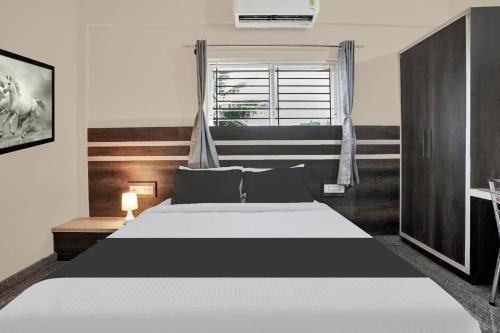 a bedroom with a large bed with a window at Super Collection O Peenya 2nd stage Formerly the JK Grand in Bengaluru