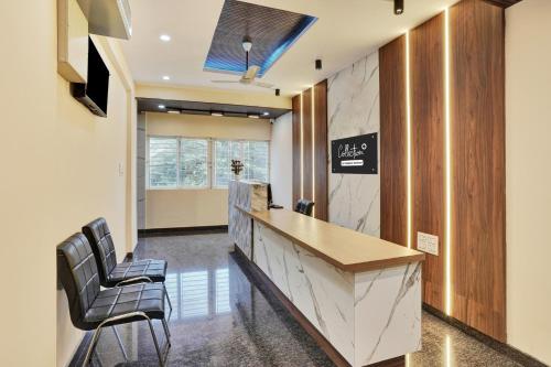 a lobby with a reception desk and two chairs at Super Collection O Peenya 2nd stage Formerly the JK Grand in Bengaluru