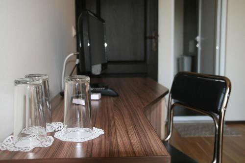 two glass vases sitting on a wooden desk at Ivatea Family Hotel in Ravda