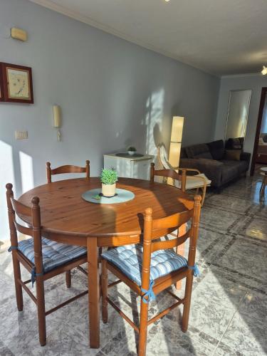 a wooden table and chairs in a living room at Apartamento Soleado cerca de la playa - WIFI in Fisterra