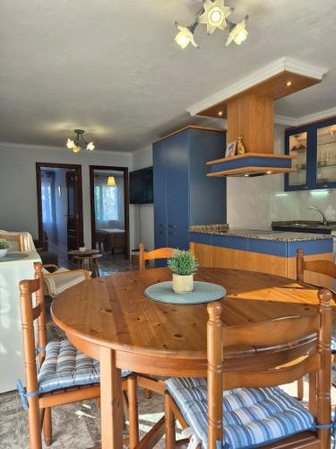 a kitchen and dining room with a wooden table at Apartamento Soleado cerca de la playa - WIFI in Fisterra