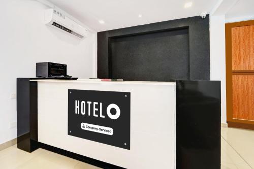 a hotel reception desk with a black and white at Super Hotel O Technopark Formerly Le Frank in Trivandrum