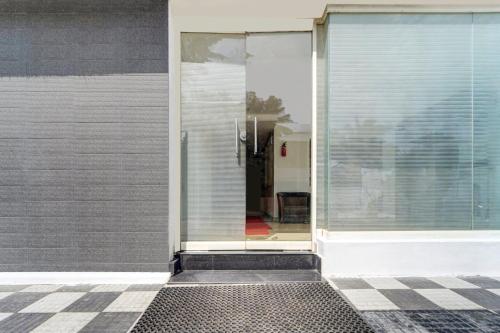 an open glass door on a building with a tile floor at Super Hotel O Technopark Formerly Le Frank in Trivandrum