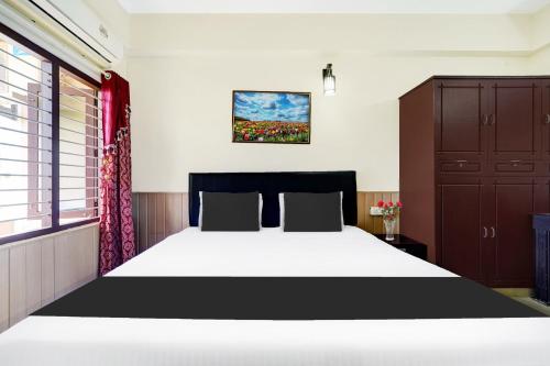 a bedroom with a large bed and a window at Super Hotel O Technopark Formerly Le Frank in Trivandrum