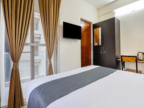 a bedroom with a bed and a large window at Super Townhouse Bellandur Near Embassy Tech Village in Bengaluru