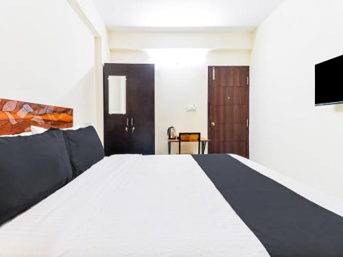 a bedroom with a large white bed and a tv at Super Townhouse Bellandur Near Embassy Tech Village in Bengaluru