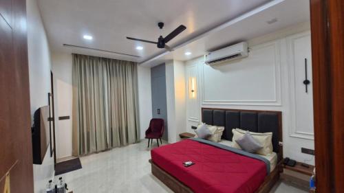 a bedroom with a red bed with a red blanket at New Kanha Hotel in Jaipur