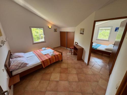 ein kleines Zimmer mit einem Bett und einem Spiegel in der Unterkunft Rose Wind Apartments by Pag tours in Pag