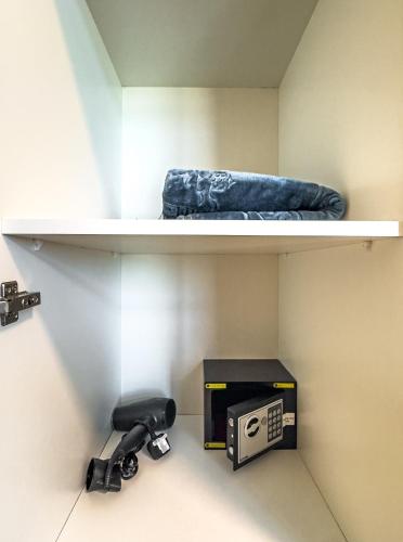 a shelf with a phone and a box on it at Great Fully Equipped 1BDR Apartment in Masdar for 4 Pax in Abu Dhabi