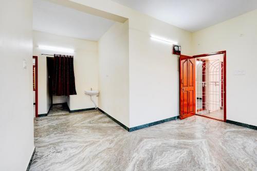 an empty room with white walls and a red door at Super Hotel O Thoraipakkam Chennai in Chennai
