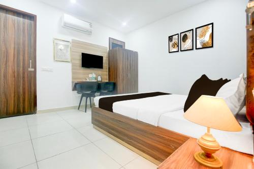 a bedroom with a bed and a desk with a chair at Super Collection O Sherpur Road Near Mohan Dai Oswal Hospital in Ludhiana