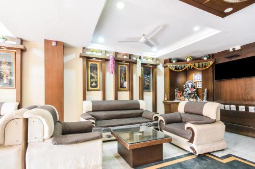 a living room filled with furniture and a flat screen tv at Townhouse OAK Secunderabad Near Railway Station Formerly Hotel Brahma in Hyderabad