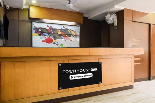 a front desk with a townhousawn bank sign at Townhouse OAK Secunderabad Near Railway Station Formerly Hotel Brahma in Hyderabad