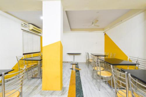 a room with tables and chairs and a wall at Townhouse OAK Secunderabad Near Railway Station Formerly Hotel Brahma in Hyderabad