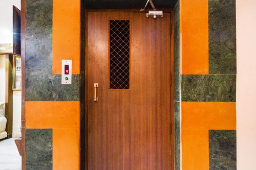a wooden door in a building with an orange at Townhouse OAK Secunderabad Near Railway Station Formerly Hotel Brahma in Hyderabad