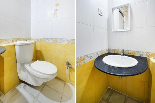 a bathroom with a toilet and a sink at Townhouse OAK Secunderabad Near Railway Station Formerly Hotel Brahma in Hyderabad