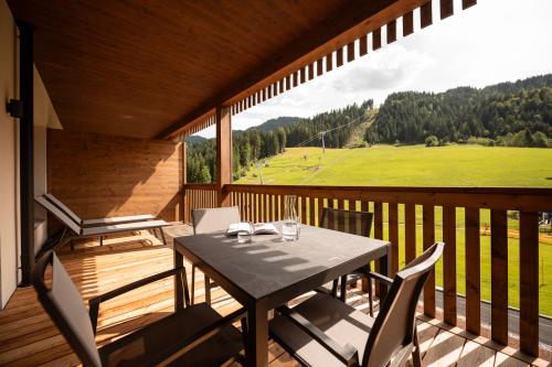 a table and chairs on a balcony with a view at ADEA Lifestyle Suites Fieberbrunn in Fieberbrunn