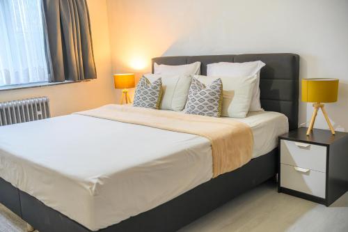 a bedroom with a large bed with pillows at Villa-gey Escape in Bekkevoort