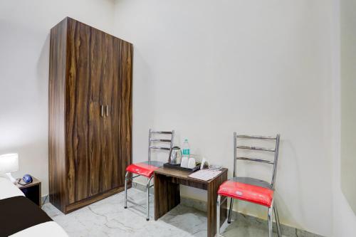 a desk with two chairs and a wooden cabinet at Super Collection O Chikmagalur Market Road in Chikmagalūr