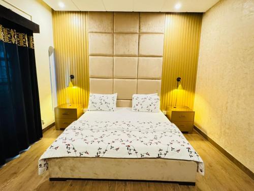 a bedroom with a bed and two lamps on the wall at Crest View Guest House Islamabad in Islamabad