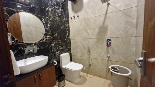a bathroom with a sink and a toilet and a mirror at New Kanha Hotel in Jaipur
