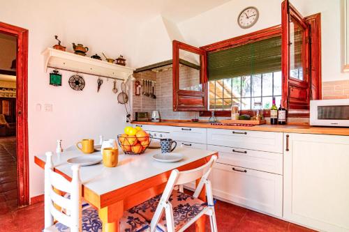 una cucina con tavolo, sedie e forno a microonde di Edomus Castillo de las Guardas a Siviglia