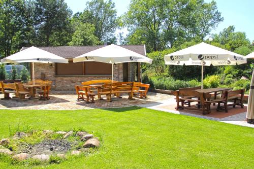 a group of picnic tables and umbrellas in a yard at An-Son Apartamenty in Zielona Góra