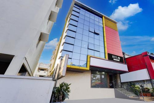 a hotel building with a yellow and red facade at Super Hotel O Porur Formerly Jeya's Elite in Chennai