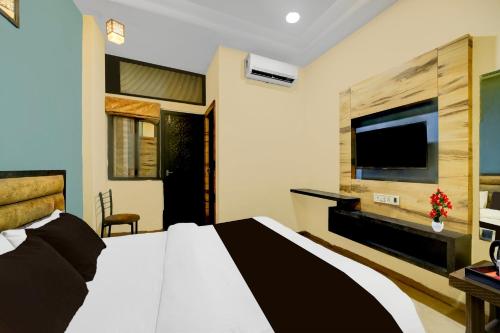 a bedroom with a bed and a flat screen tv at Super Collection O ISKCON Radha Govind Formerly Hotel Shivom in Indore